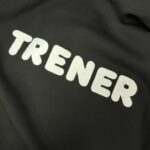 Czarna bluza z napisem TRENER, uszyta w pracowni Malleaa